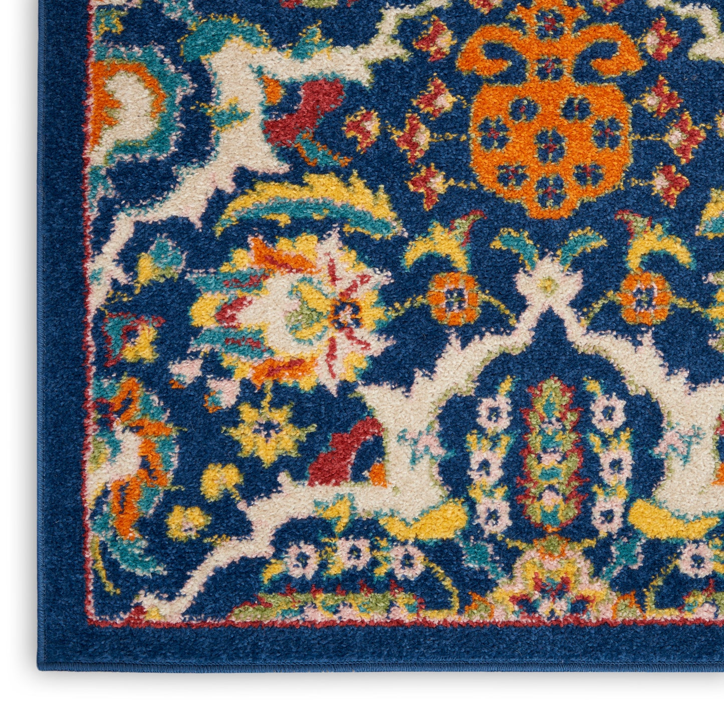 Close-up of a blue Persian-style rug corner with multicolor floral motifs and a dark blue border.