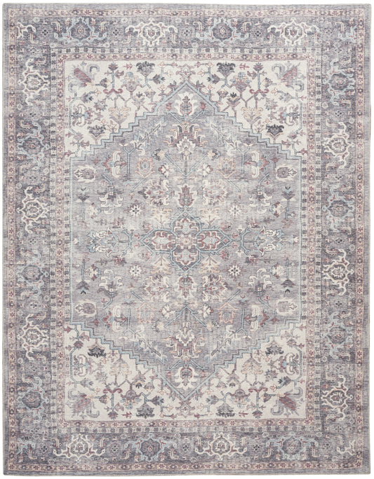 Vintage-style Persian area rug with soft blue-gray tones, ivory and blush floral motifs, central medallion, bordered frame.