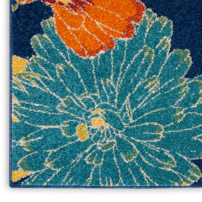 Rectangular teal floral shag rug with large turquoise petals, orange blossom accent, yellow centers on dark blue background.