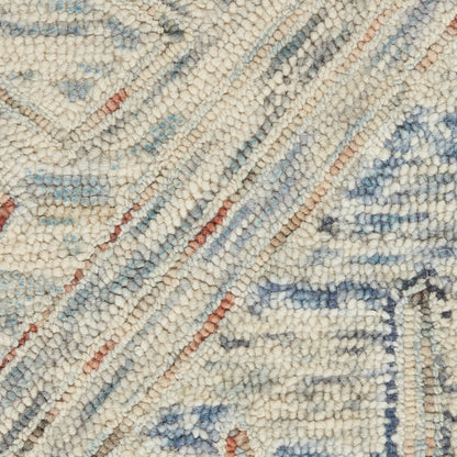Close-up of a cream geometric rug with pale blue and rust accents and a textured looped pile.