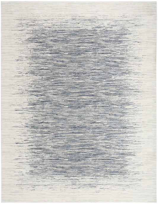 Rectangular area rug with cream background and navy-blue horizontal brushstrokes forming a soft, blurred central band.