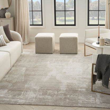 Bright contemporary living room with a beige rug, white sofa, beige ottomans, round coffee table, and black-framed windows.