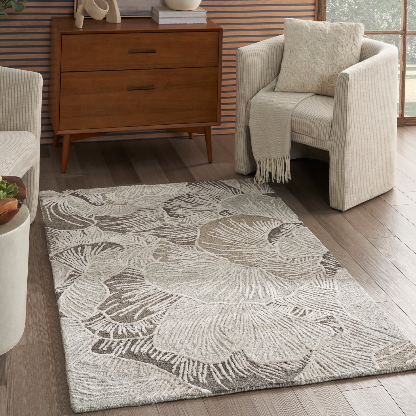 Rectangular light gray textured area rug with a large abstract shell motif; plush pile, modern living room.