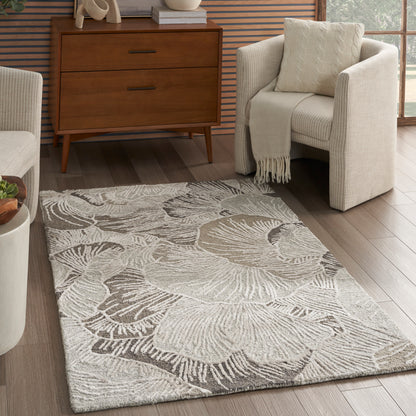 Rectangular light gray textured area rug with a large abstract shell motif; plush pile, modern living room.