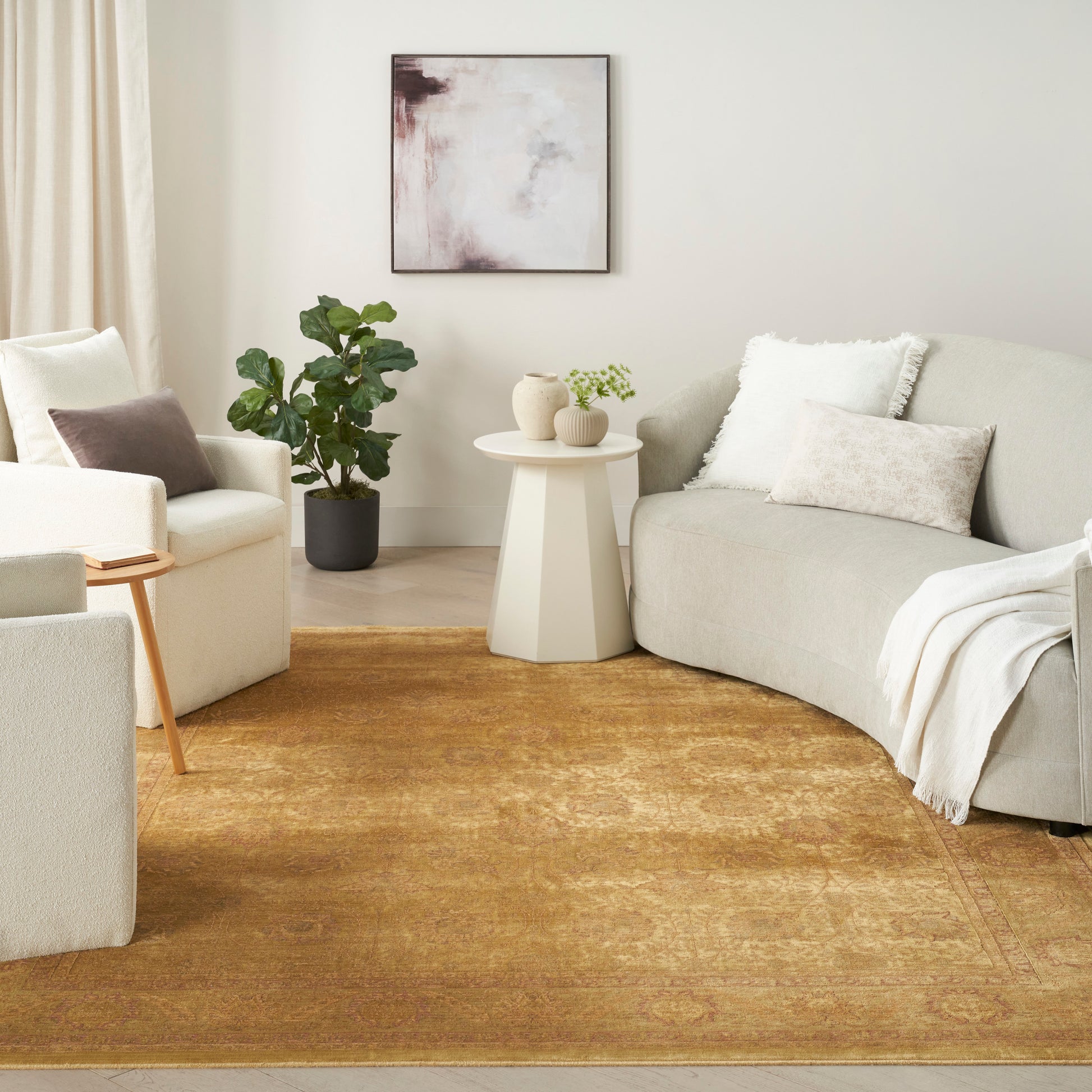 Golden-brown vintage-style area rug with muted floral pattern and soft pile in a cream living room with beige sofas.