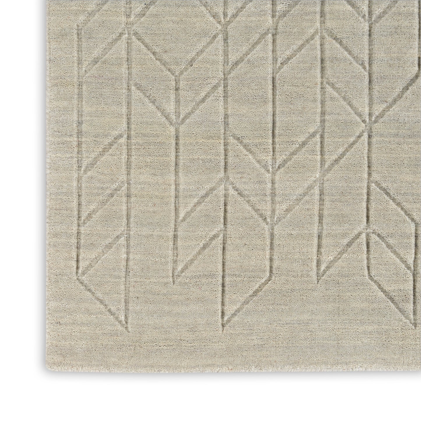 Beige area rug with subtle taupe geometric chevron/tree-branch pattern and woven texture.