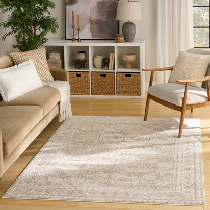 Neutral beige area rug on light wood floor; beige sofa, wooden chair, white cubbies with wicker baskets.