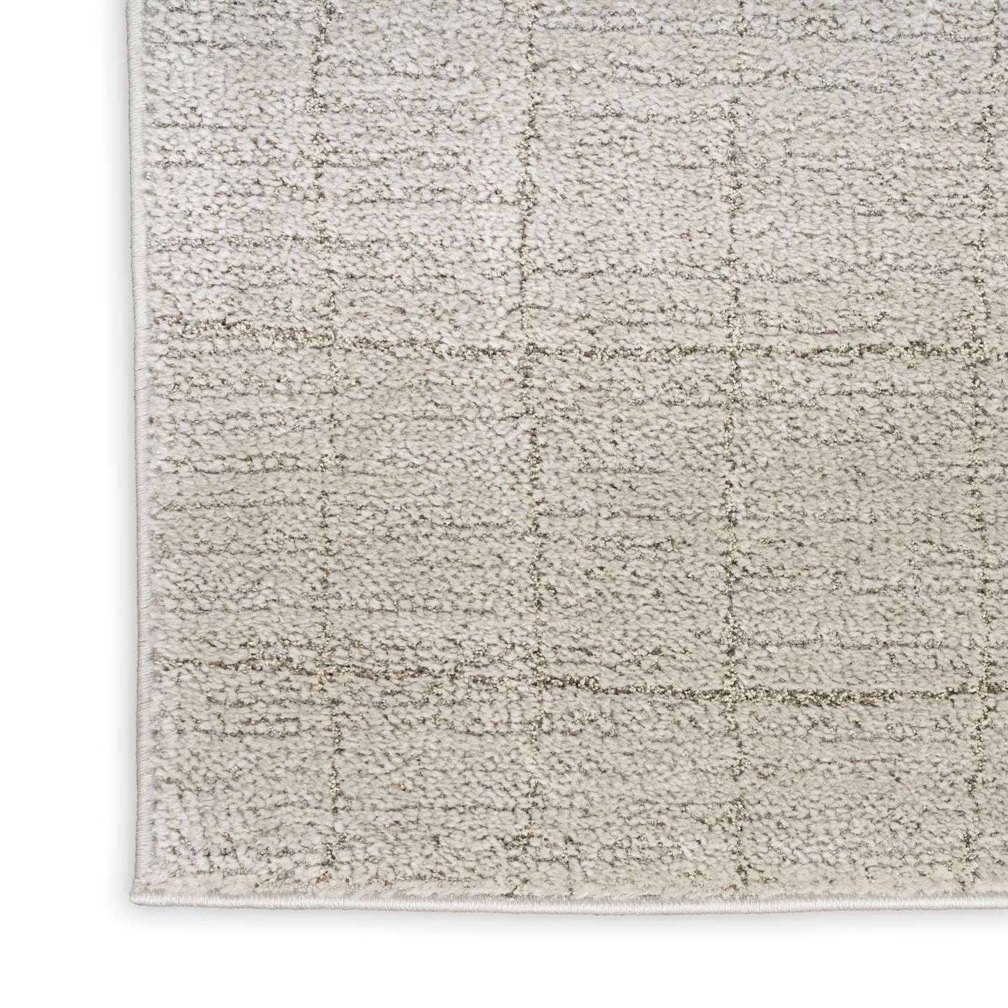 Neutral cream-beige shag rug with a subtle square-grid pattern and bound edges.