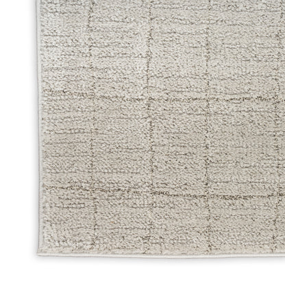 Neutral cream-beige shag rug with a subtle square-grid pattern and bound edges.