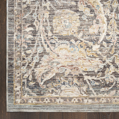 Grey-blue Persian-style ornate area rug corner with cream and gold floral motif on dark wood floor.
