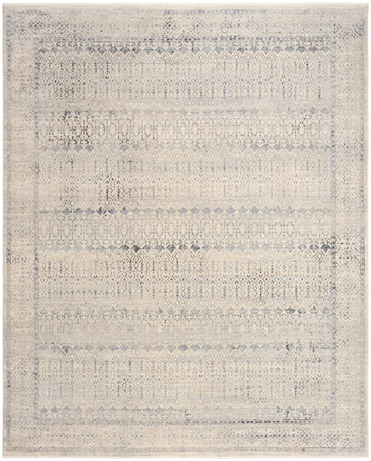 Distressed beige-blue oriental area rug with faded diamond motifs and a bordered frame.