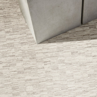 Two light-gray panels meet at a corner on a beige textured runner rug.