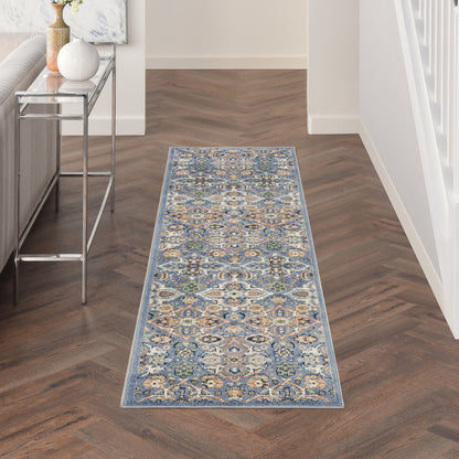Blue oriental runner rug with cream and gold motifs on dark herringbone hallway floor beside a metal-glass console table.