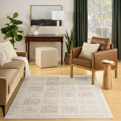Cozy living room scene: beige sofa, brown leather armchair, cream ottoman, wooden console, patterned rug, plants and green curtains.