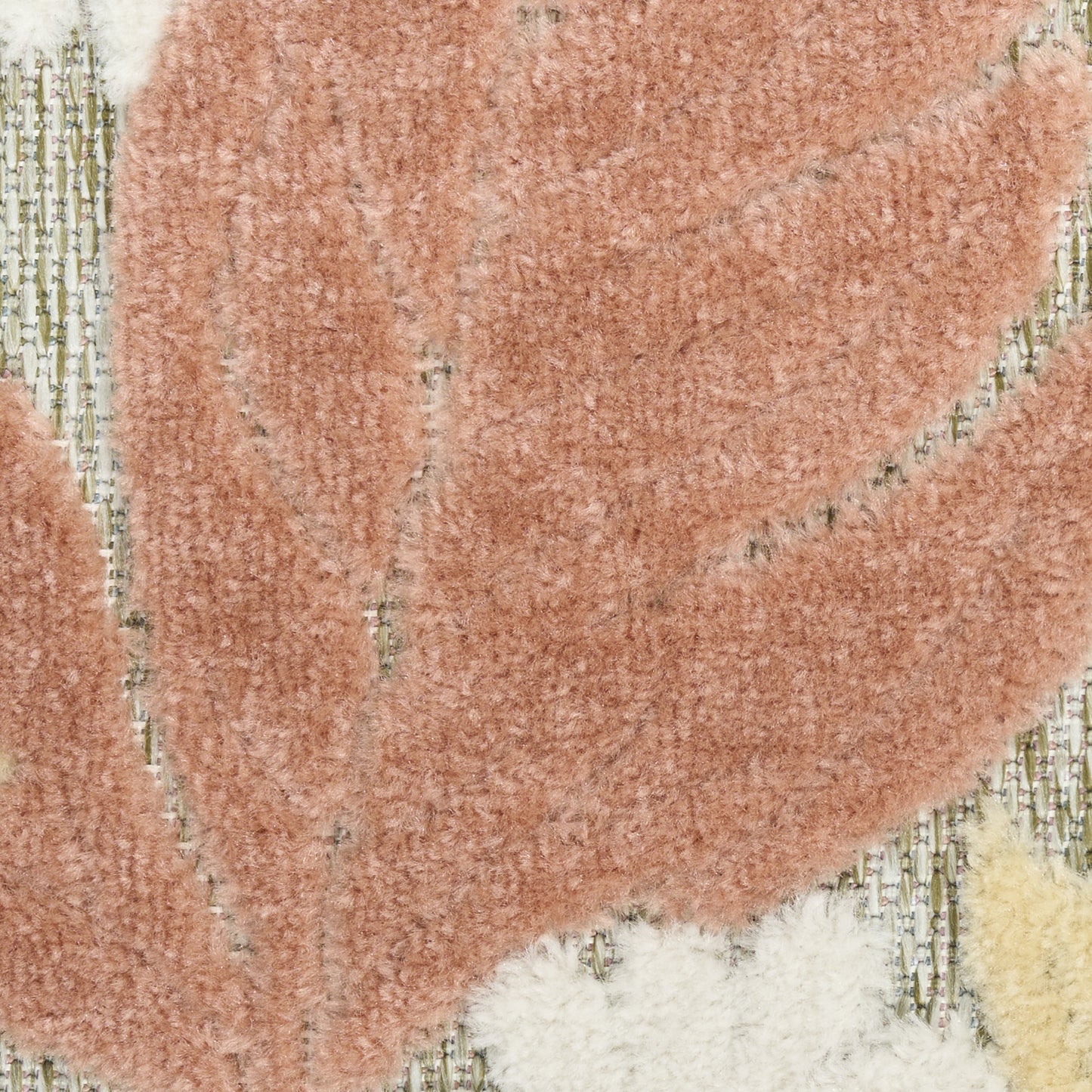 Close-up of a peach shag rug with abstract cream and beige leaf-like shapes on a pale background; soft plush pile.