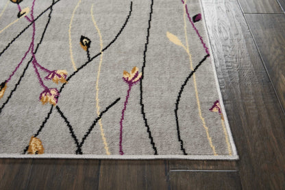 Grey abstract floral area rug with black, purple and yellow curved lines, light border, on dark wood floor.