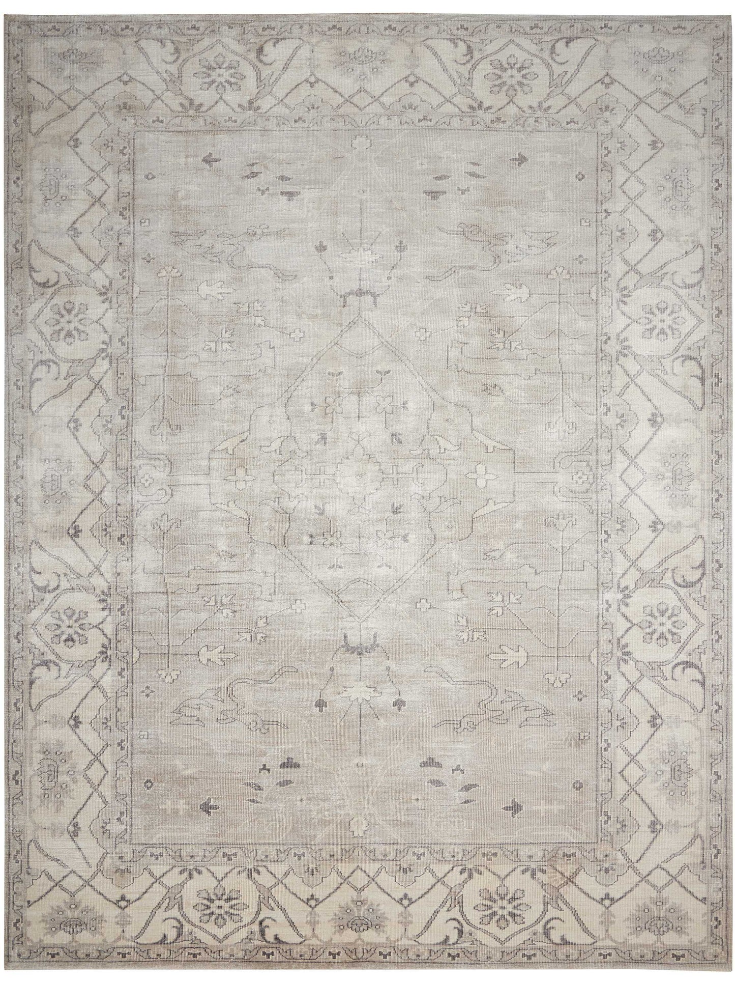 Muted gray-beige oriental rug with a subtle central medallion and ornate floral border.