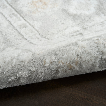 Soft light-gray plush shag area rug on dark wooden floor.