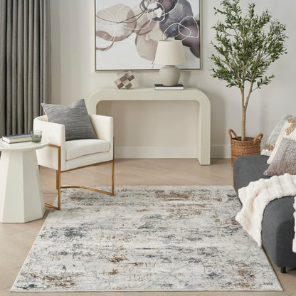 Neutral living room with cream console, white armchair, gray rug, potted tree in wicker basket, gray sofa with knit throw.