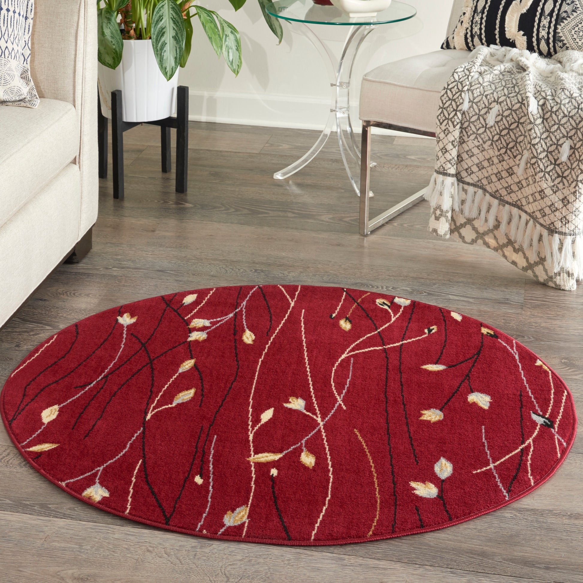 Round red area rug with white and gold botanical lines, in a cozy living room.