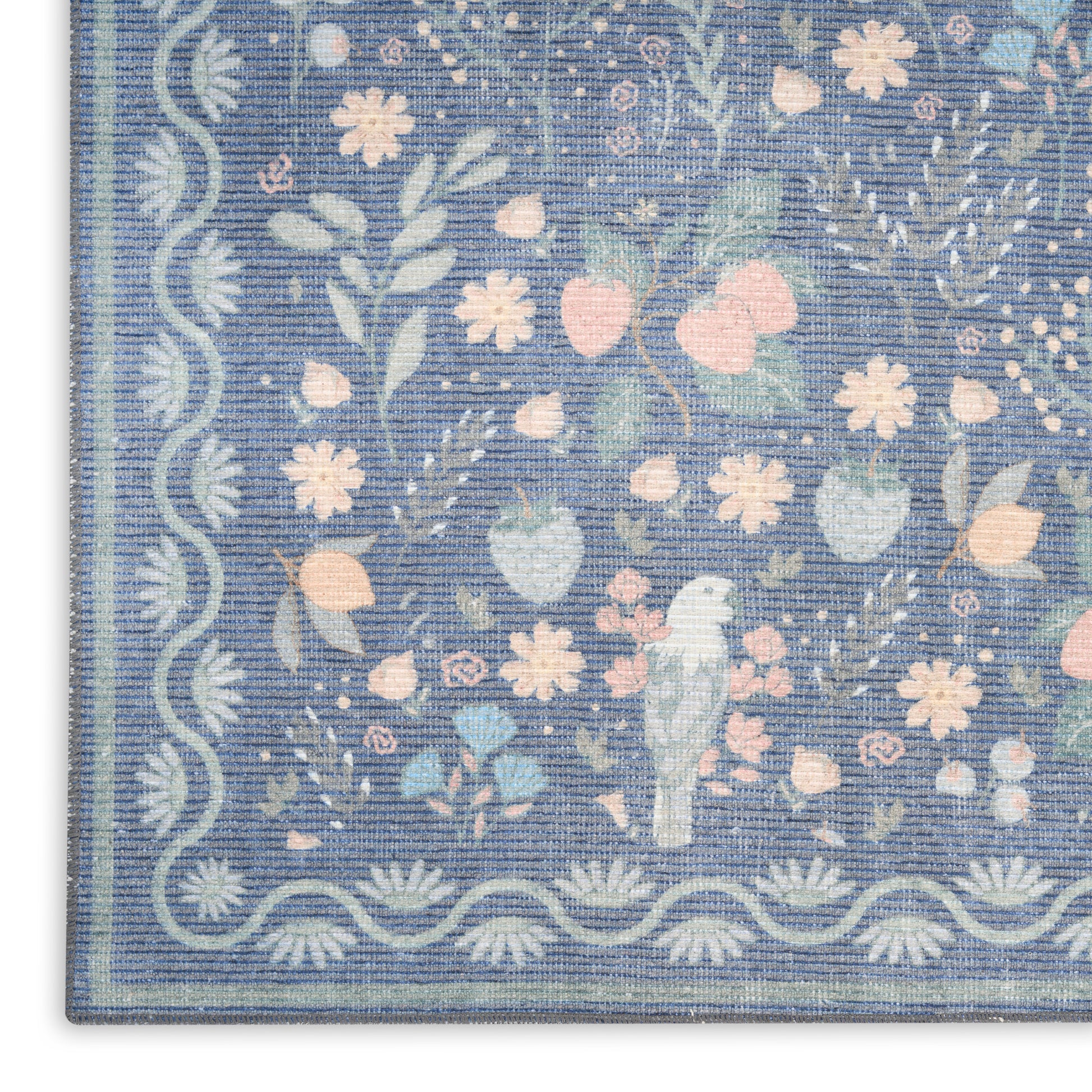 Blue floral rug with pastel pink & white flowers, light blue leaves, scalloped border & small central bird motif.