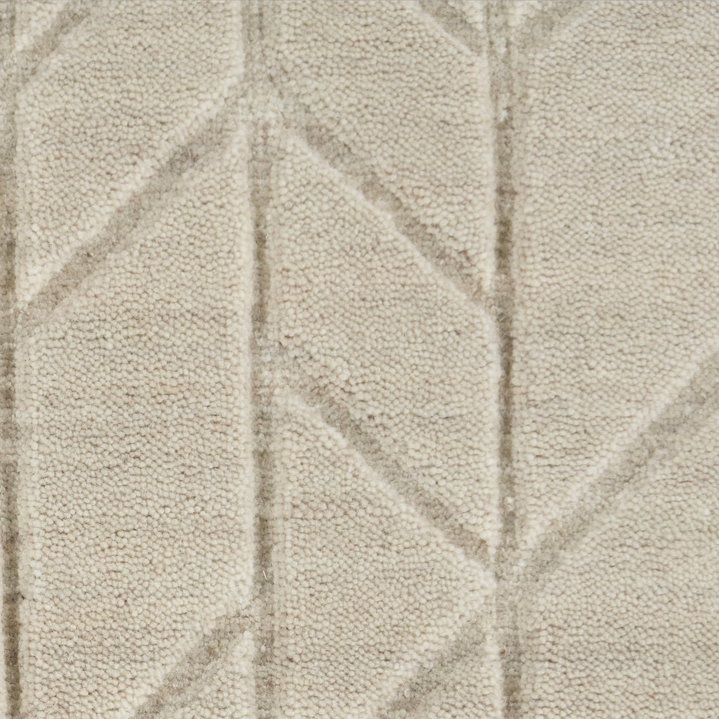 Beige loop-pile rug with subtle geometric chevron pattern and textured surface.