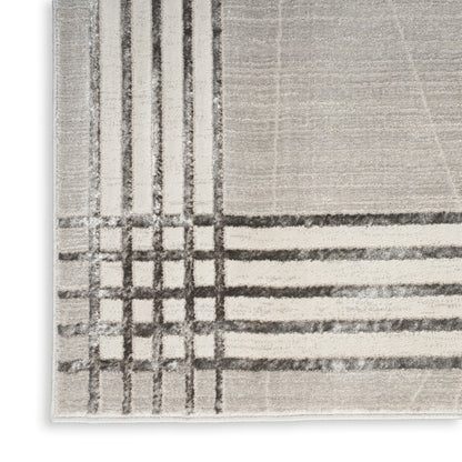 Beige plush area rug with dark gray geometric plaid lines in a modern grid pattern.
