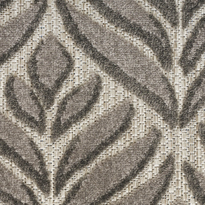 Close-up of a beige and taupe tufted rug with a geometric leaf pattern and raised pile texture.