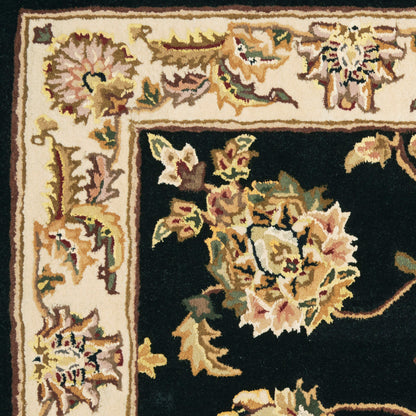 Ornate floral rug with cream border and black field; pink, gold, and green flowers in a Persian-inspired design.