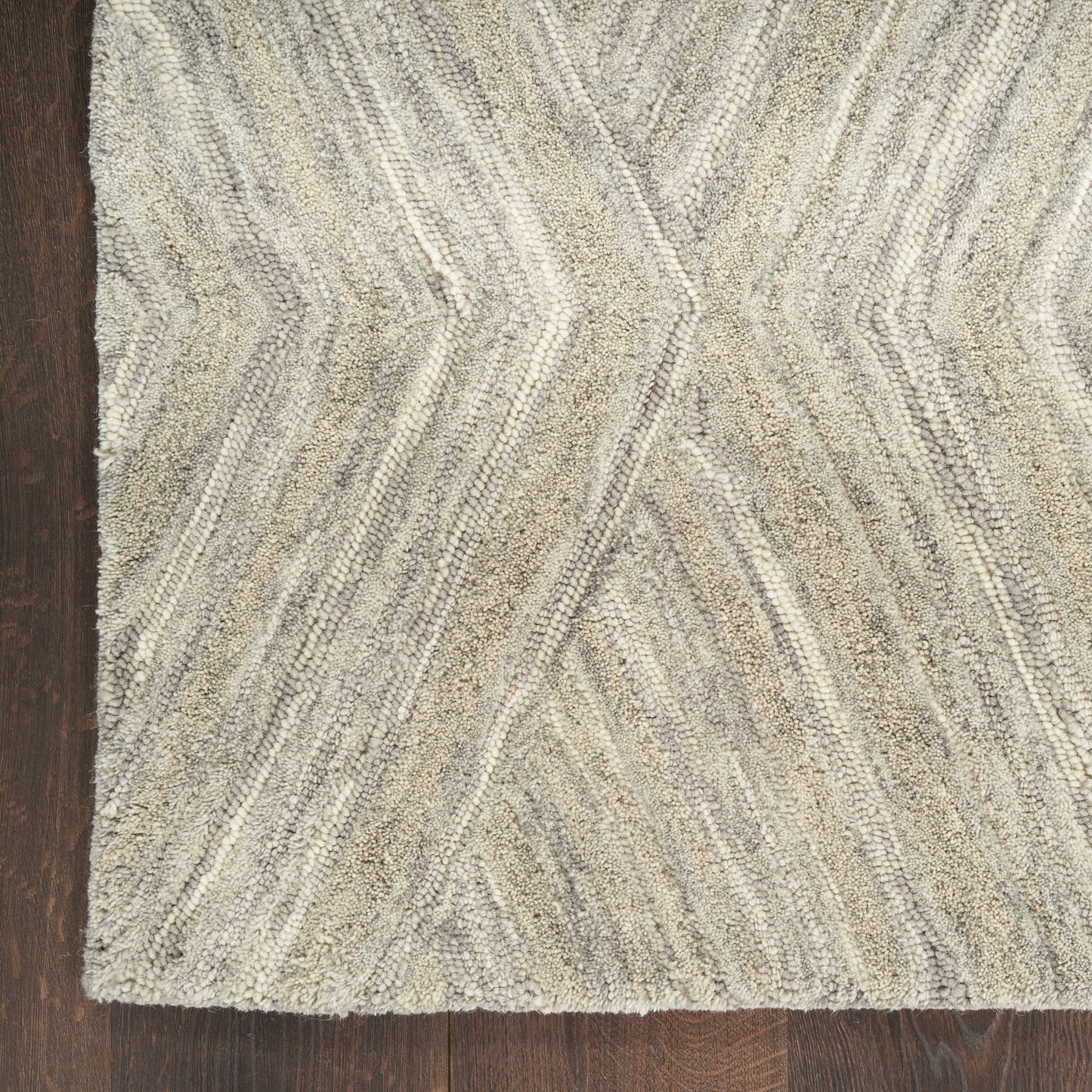 Beige-gray textured shag rug with chevron zigzag pattern on dark wood floor.