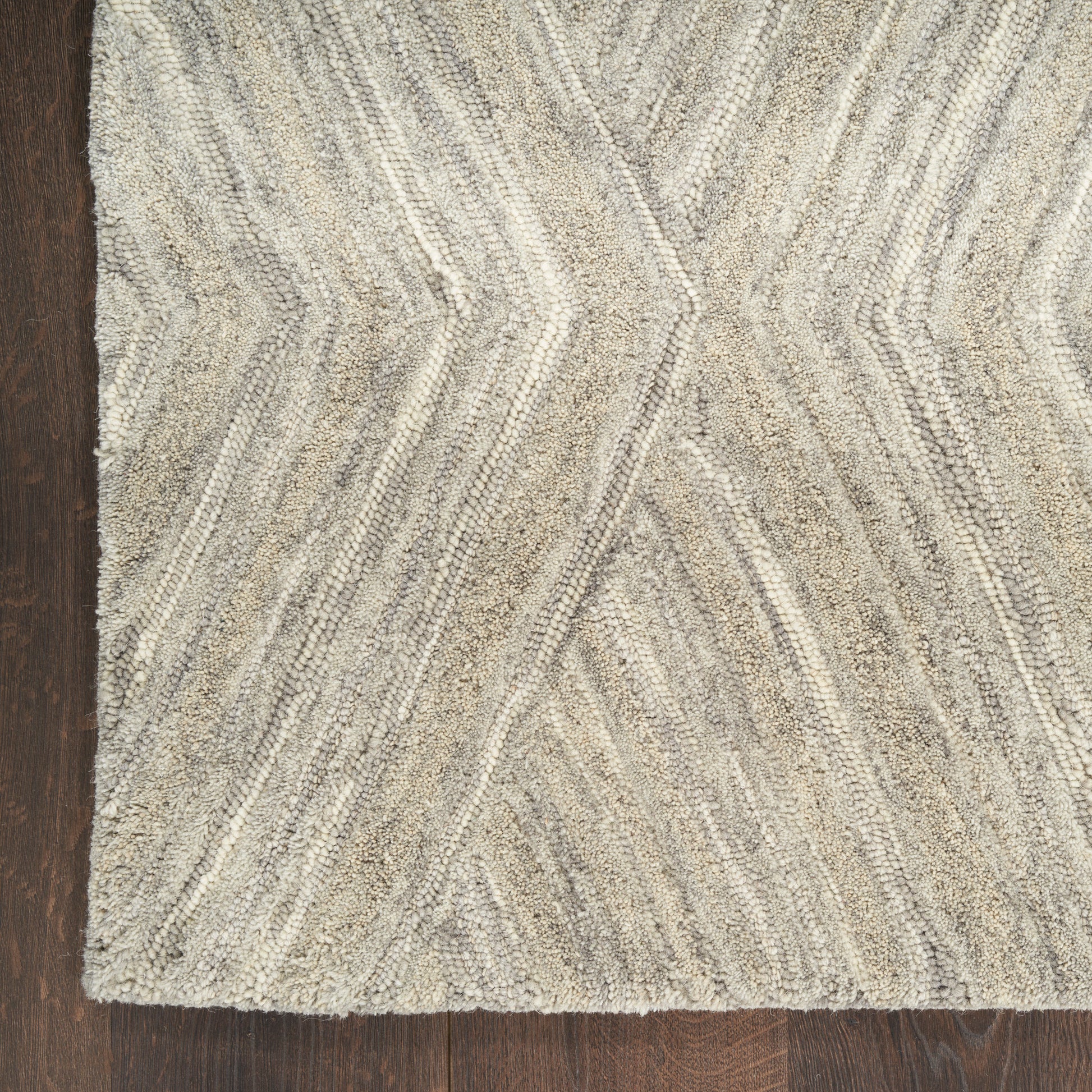 Beige-gray textured shag rug with chevron zigzag pattern on dark wood floor.