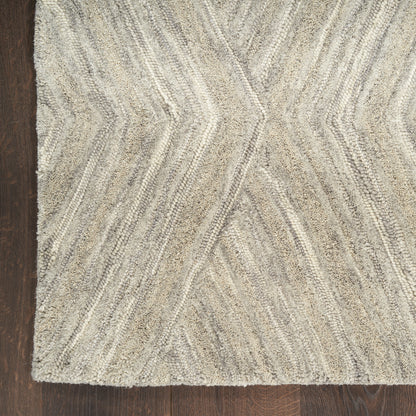 Beige-gray textured shag rug with chevron zigzag pattern on dark wood floor.