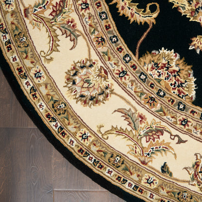 Round oriental rug with cream field, black border, & intricate gold, red & blue floral motifs.