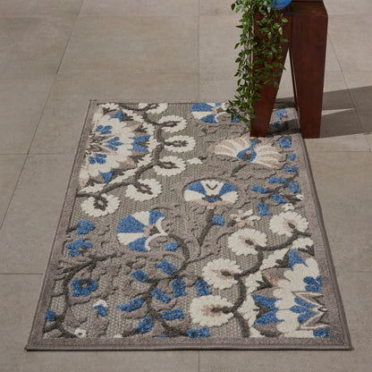 Rectangular area rug with grey base, white and blue floral damask pattern, bordered, indoor decor.
