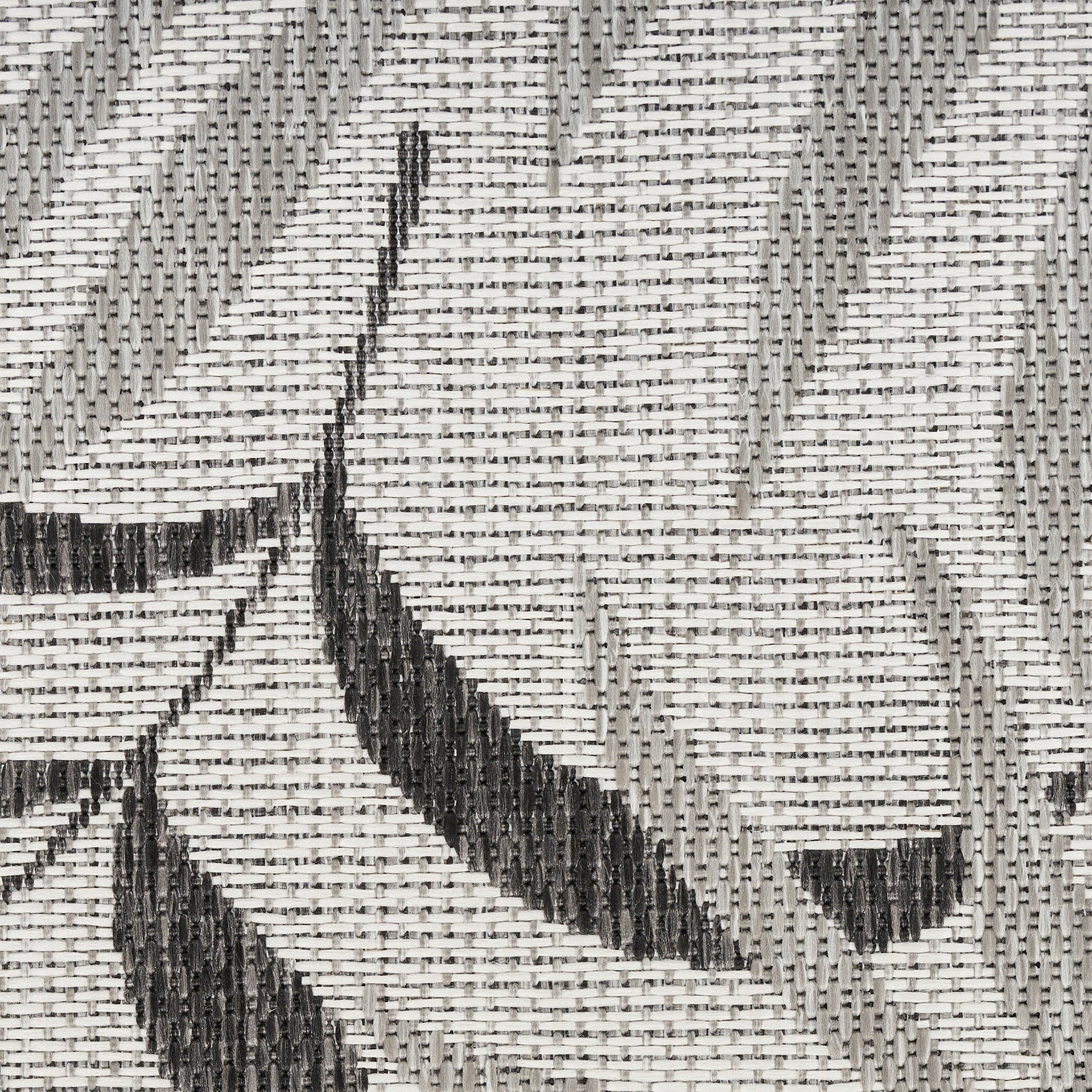 Gray and black geometric woven rug with a starburst motif in flat-weave style.