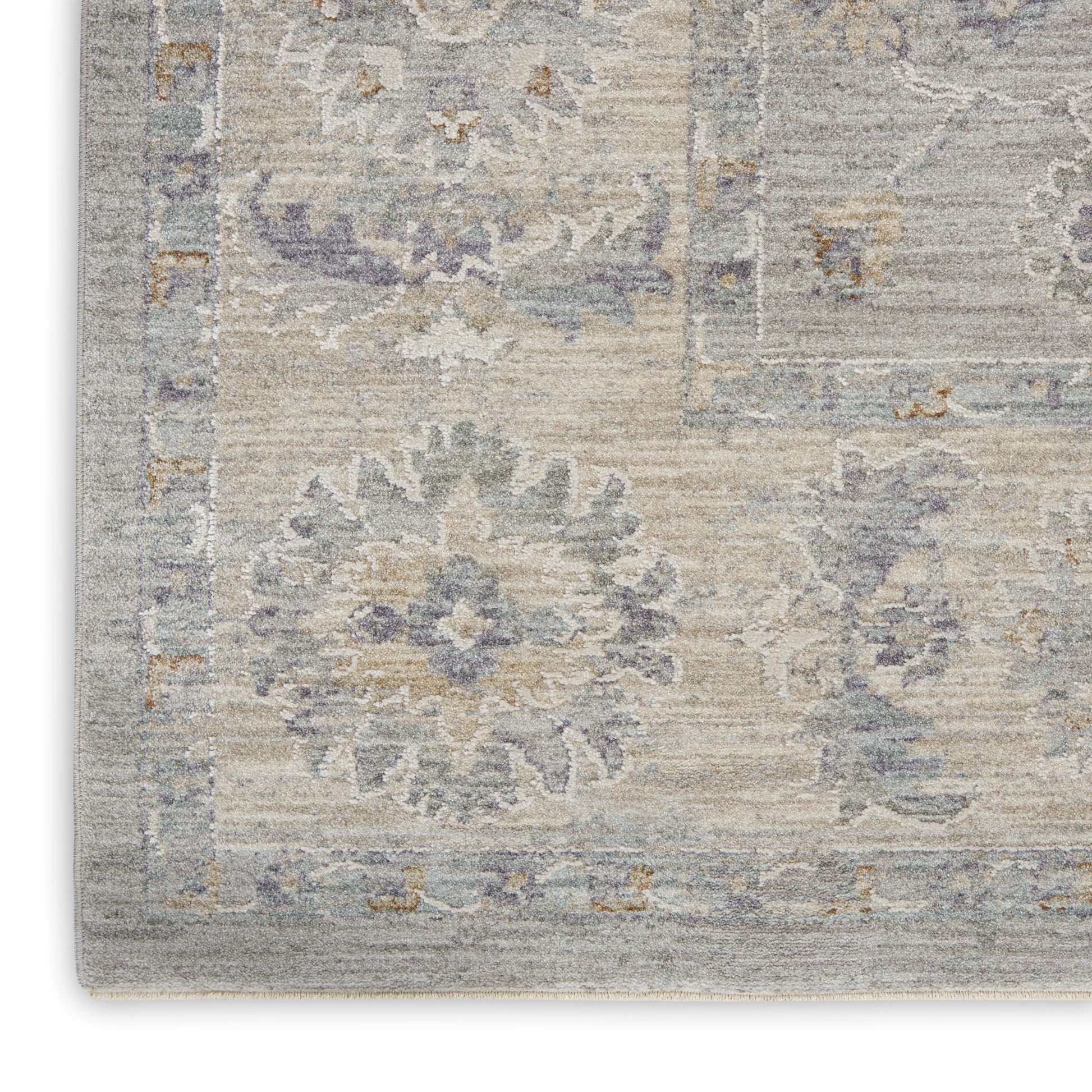 Rectangular area rug in muted gray-beige with lavender floral medallions & decorative border, distressed vintage look.