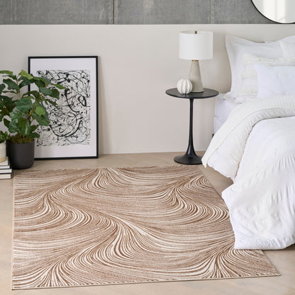 Beige swirling-pattern rug on wood floor beside white bedding, black side table with lamp, abstract art, and potted plant.