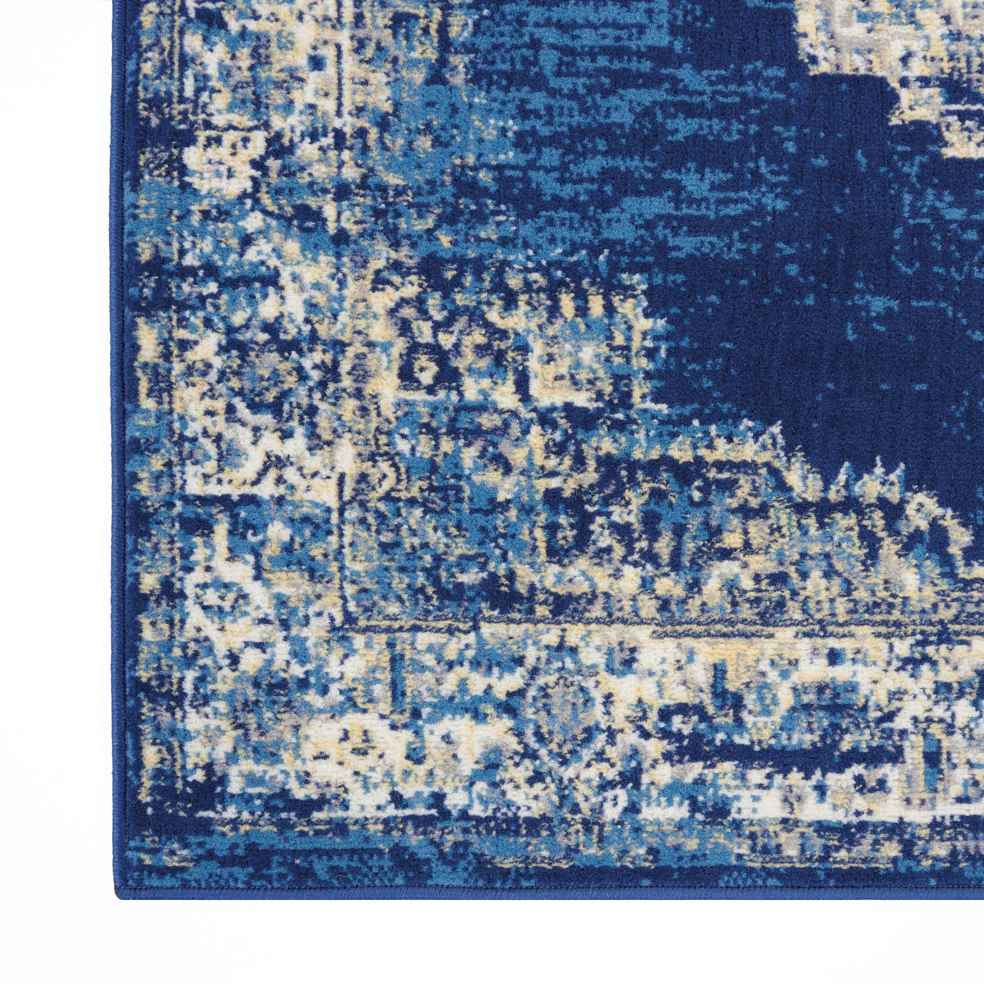 Blue abstract patterned rug with navy, light blue and beige tones and a dark border.