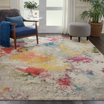 Soft beige abstract rug with bright multicolor splotches (red, yellow, blue, green) in a modern living room with blue chair.
