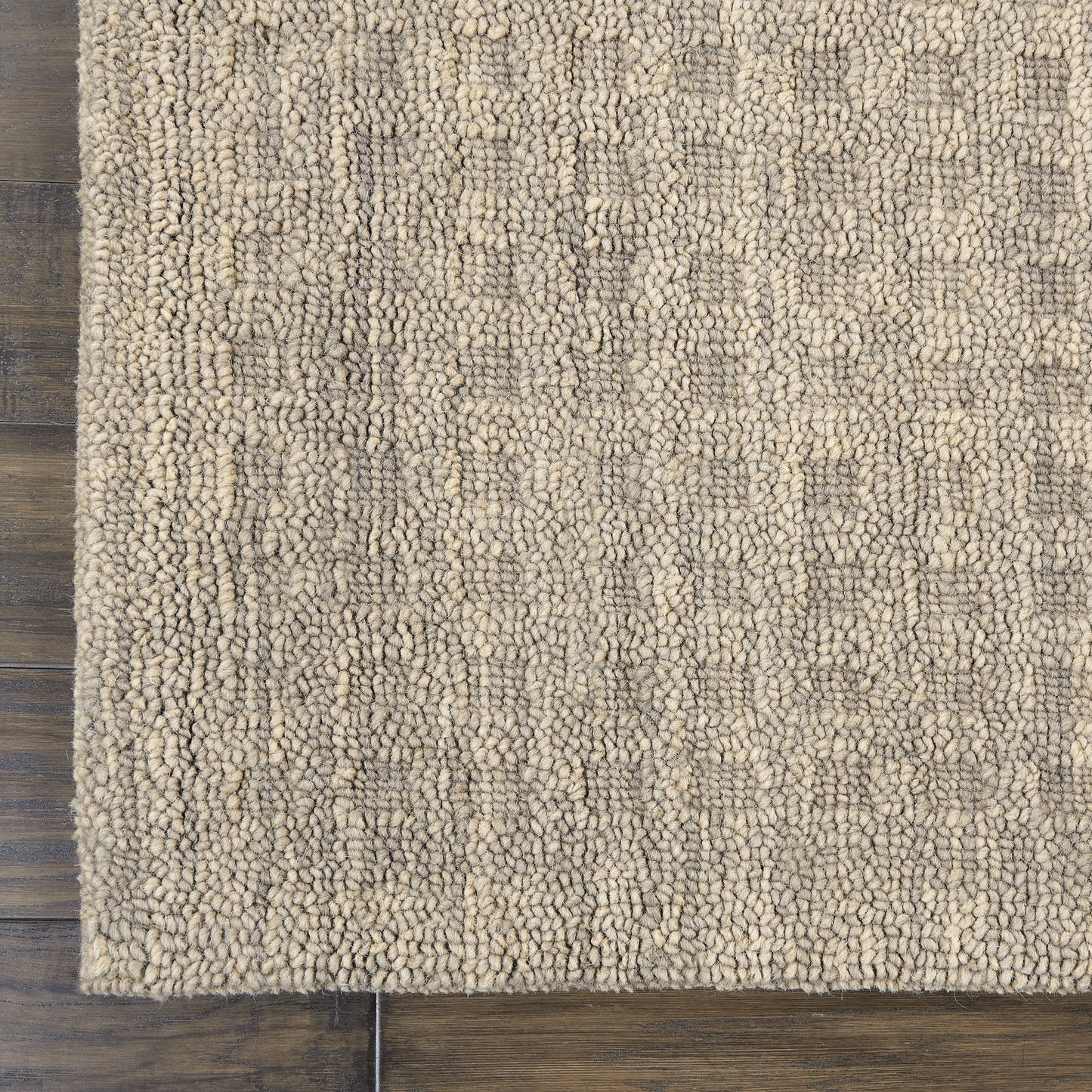 Beige boucle runner rug with dense loop-pile texture and subtle geometric pattern on dark wooden floor.