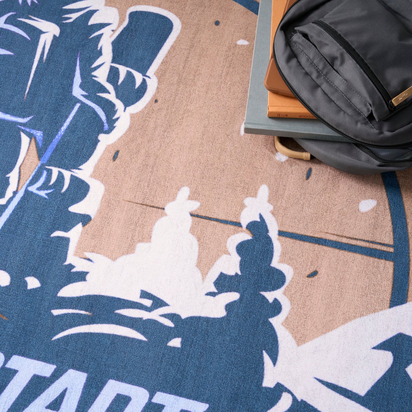 Gray rug with a blue and peach abstract pattern and white shapes.