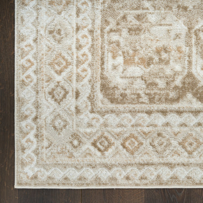 Beige oriental-style area rug with ivory medallion and geometric border on dark wooden floor.