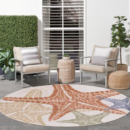 Round outdoor rug with orange starfish motif and beige, cream, blue accents; patio seating with wicker chairs.