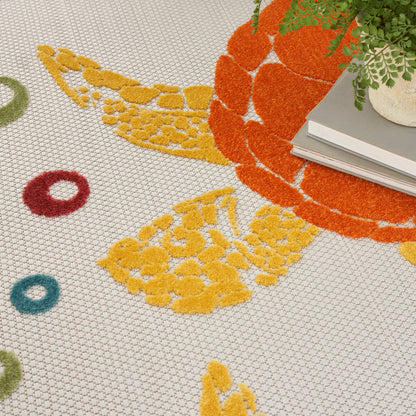 Textured loop-pile rug with bright citrus circles in yellow, orange, red, green, blue; plant and books in corner