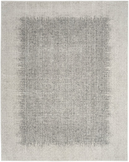 Beige distressed area rug with muted charcoal-gray center patch and lighter outer border; modern woven style.