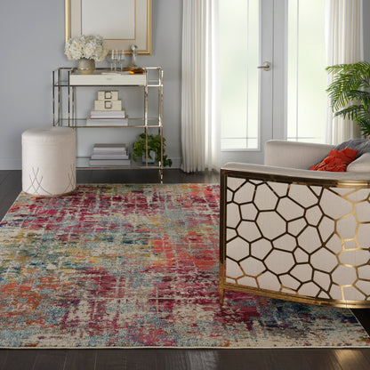 Vibrant distressed multicolor area rug on dark wood floor in a modern living room with gold honeycomb chair and glass console.