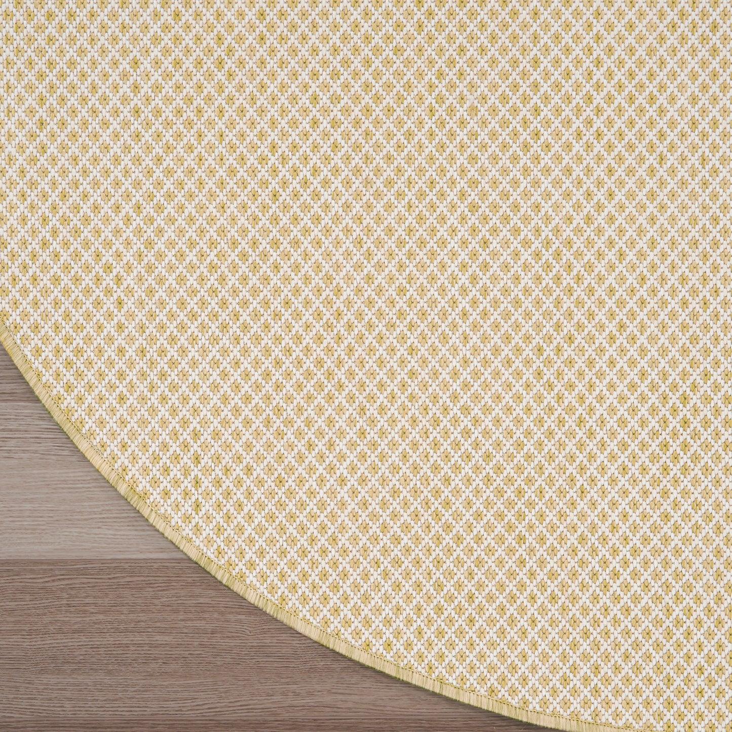 Round beige modern rug on dark wood floor, featuring a beige gradient field and a curved yellow patterned edge.