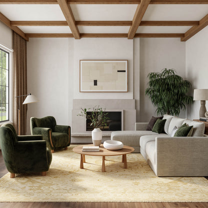 Living room with beige sofa, green velvet chairs, round wood coffee table, plant, abstract art, fireplace, and wood-beam ceiling; vintage 6' x 9' rug.