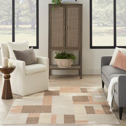 Living room scene with beige armchair, gray sofa, tall woven-front cabinet, plant basket, and beige geometric rug.