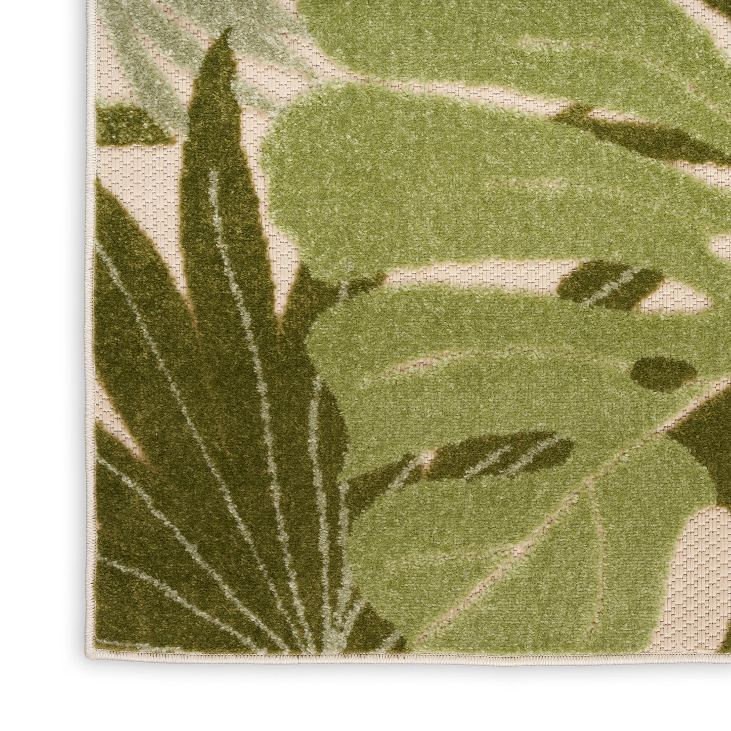 Beige outdoor rug with large dark and light green tropical leaves, tufted pile, natural botanical design.